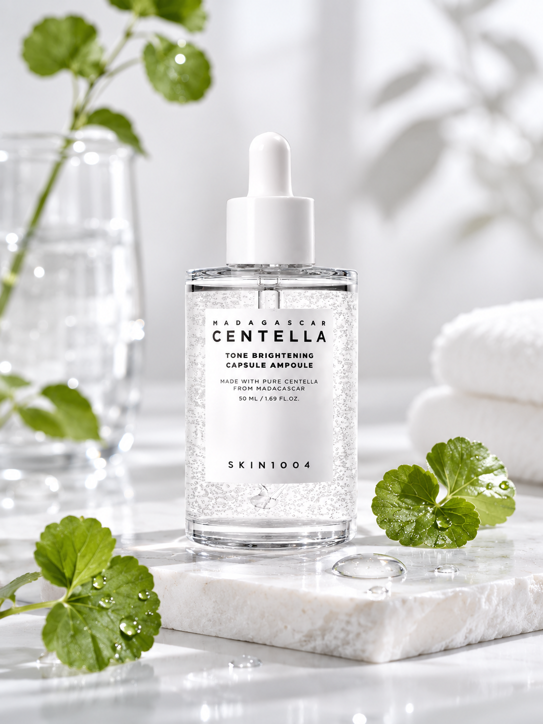 SKIN1004 Madagascar Centella Tone Brightening Capsule Ampoule 50ml on a marble surface with green leaves.