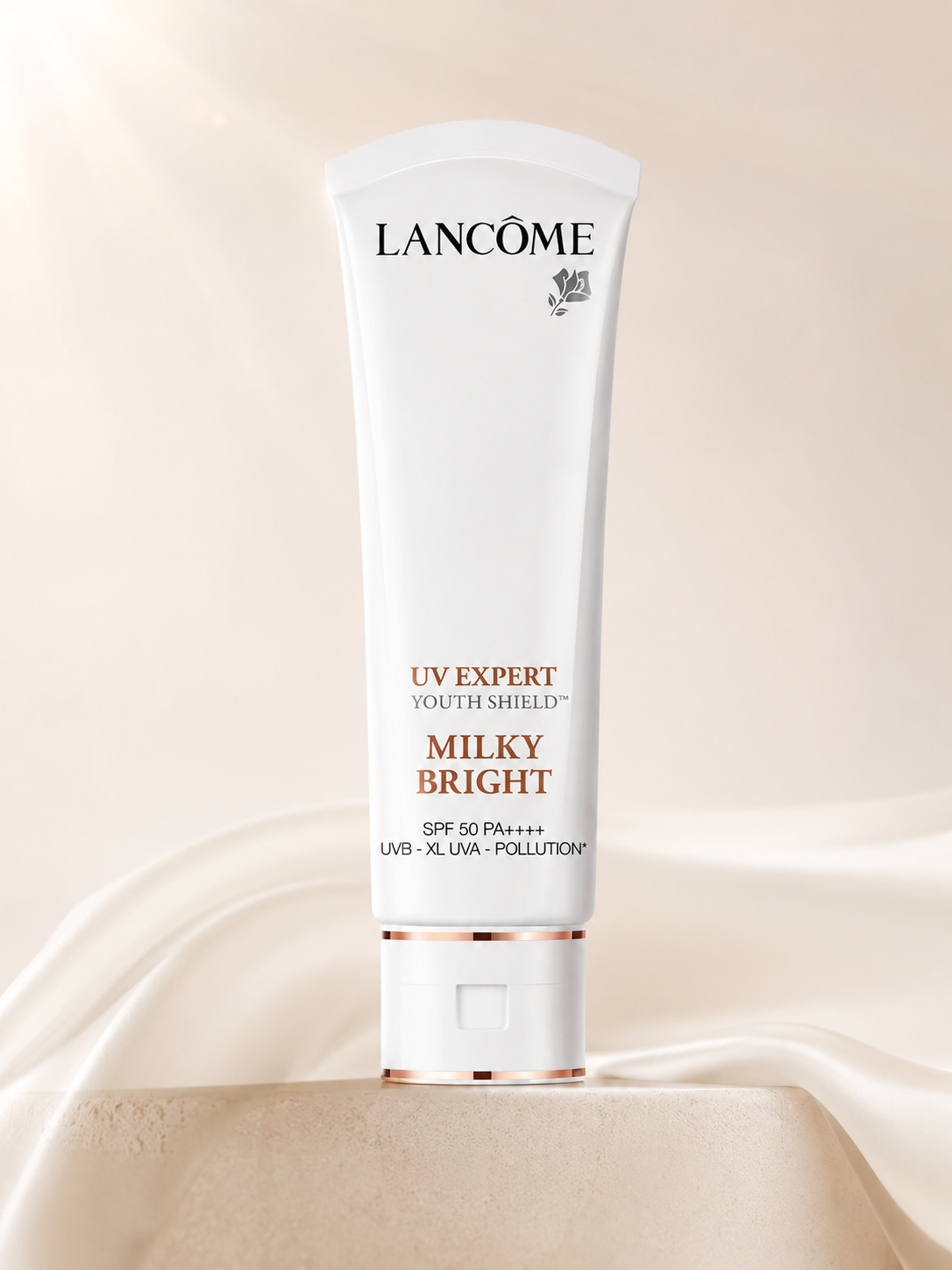 Lancôme UV Expert Milky Bright SPF50 PA++++ 50ml tube on a beige background.
