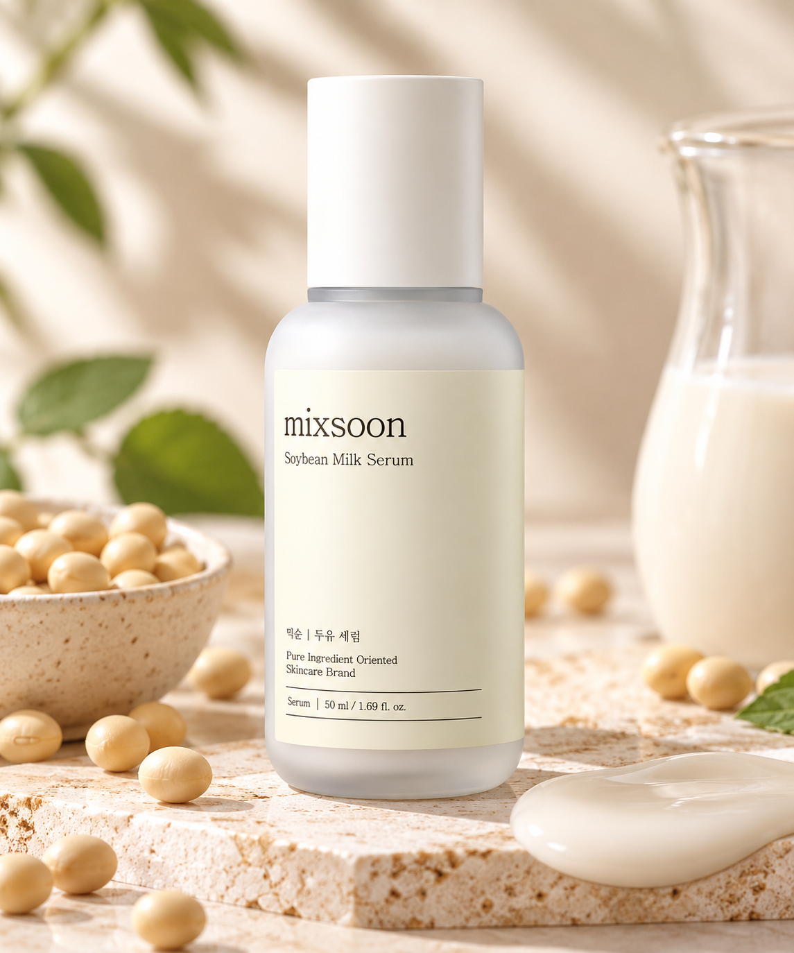 Mixsoon Soybean Milk Serum 50ml, Korean hydrating facial serum in a minimalist frosted bottle, displayed on natural beige stone with soybeans, fresh green leaves and a creamy serum texture. Nourishing K-beauty skincare inspired by soybean milk for soft, smooth, moisturized and radiant-looking skin.